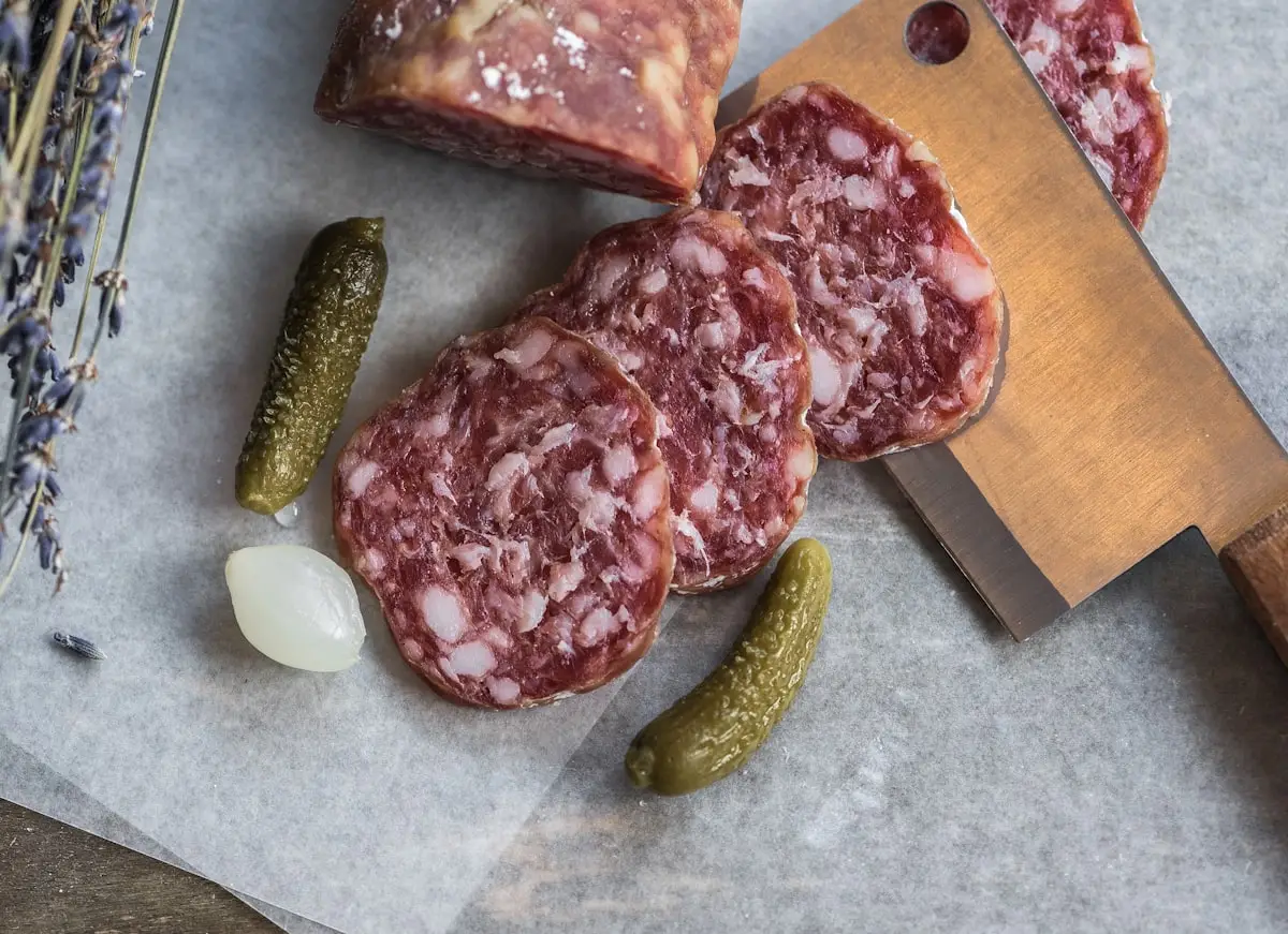 Saucisson tranché, cornichons et couteau