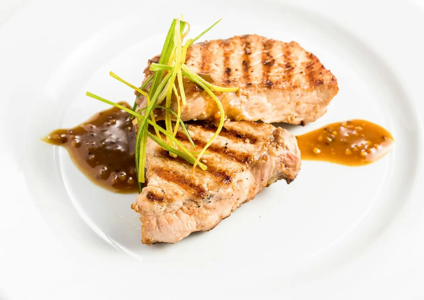 Plat du jour dressé avec soin, viande grillée et sauce